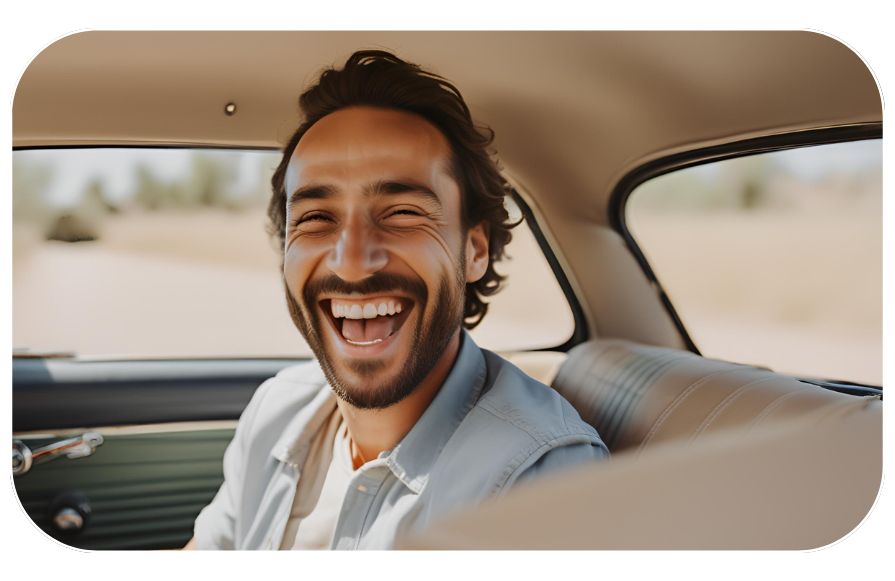 Hombre feliz en su coche al haber comparado entre los mejores seguros de coche